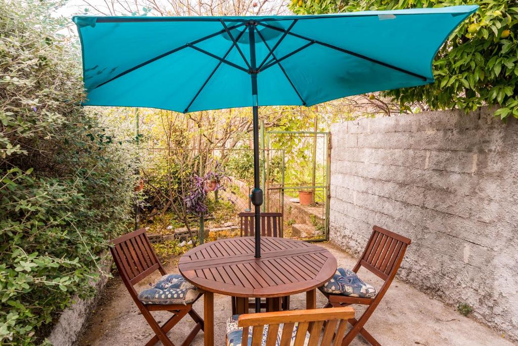 a table and two chairs with a blue umbrella at Deluxe Duplex House With Terrace in Dubrovnik
