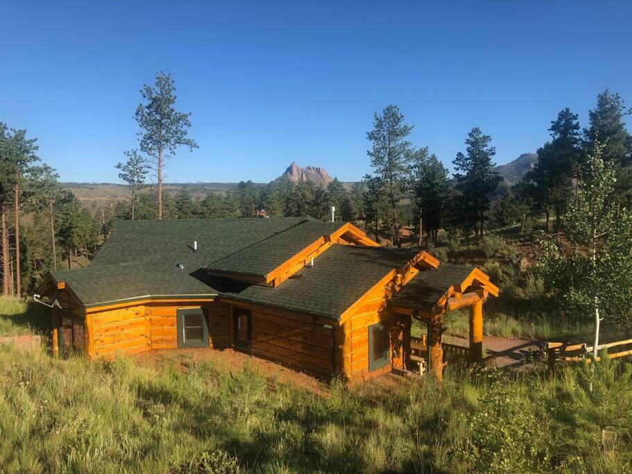 a log cabin in the middle of a field at Pikes Peak Resort - Bear Den Cabin - Where Luxury and Wilderness Meet in Westcreek