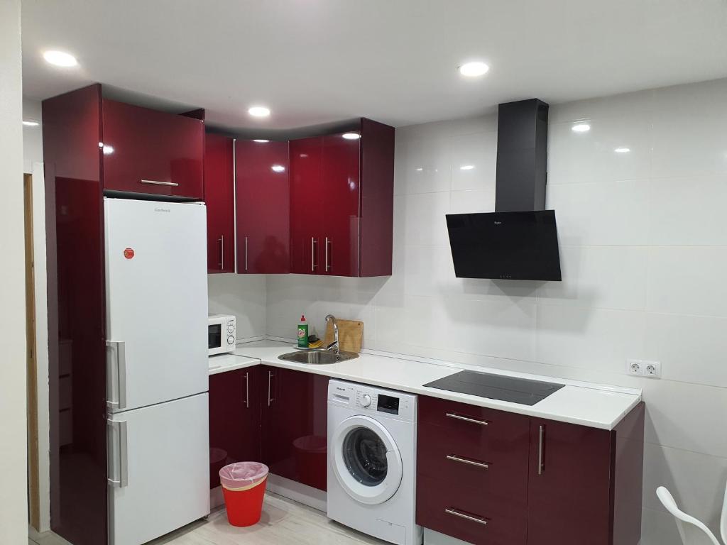 a kitchen with red cabinets and a washing machine at CASA PARAISO 2 in Corralejo