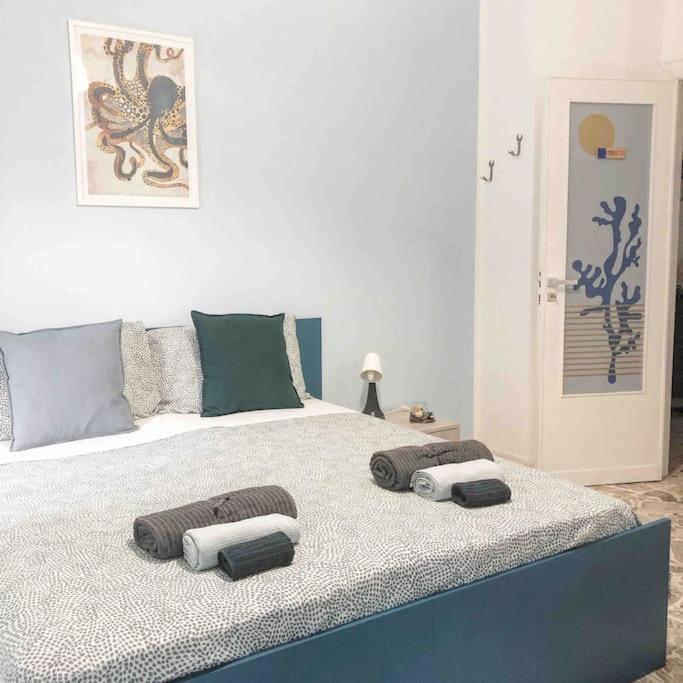 a large bed with three pillows on top of it at Tabula House - 4 ELEMENTS in Catania