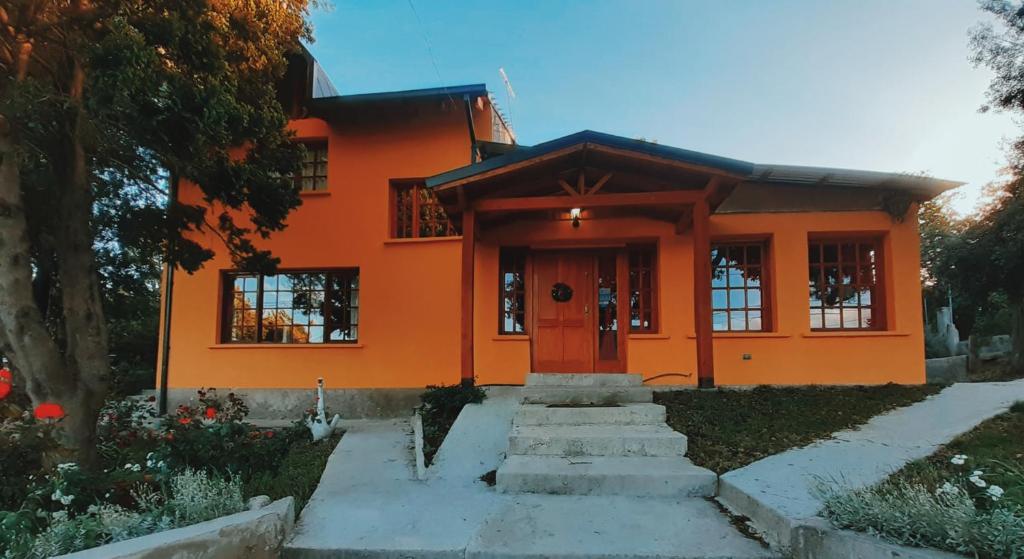 ein orangenes Haus mit einer Treppe, die dorthin führt in der Unterkunft Alojamiento Los Alelies in San Carlos de Bariloche