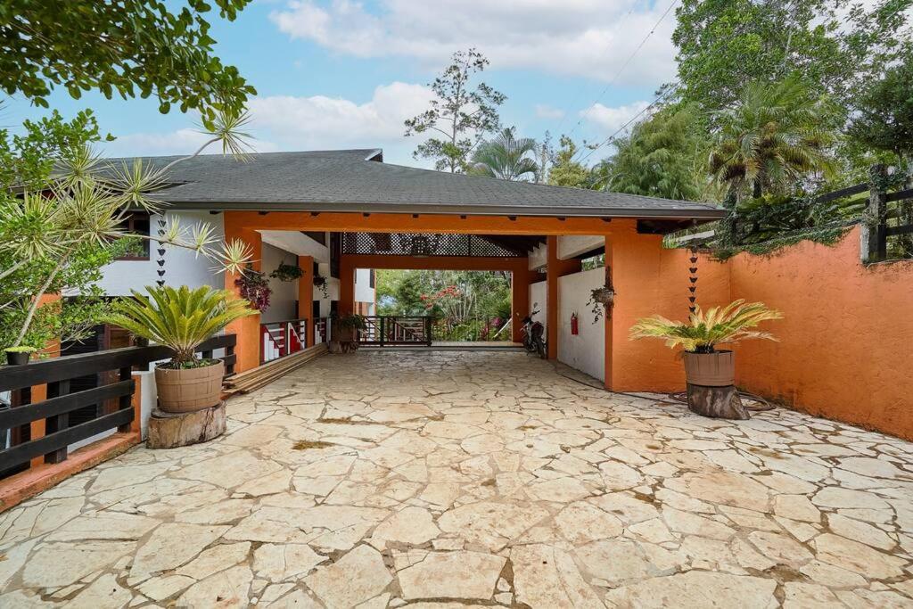 ein Haus mit einer Terrasse mit Pflanzen davor in der Unterkunft Villa ines-4X4only-Jarabacoa-View-Jacuzzi-5BR in Jarabacoa