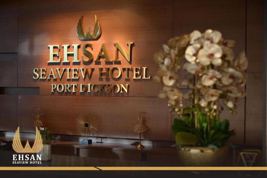 a sign for a hotel with a vase of flowers at EHSAN SEAVIEW HOTEL PORT DICKSON in Port Dickson