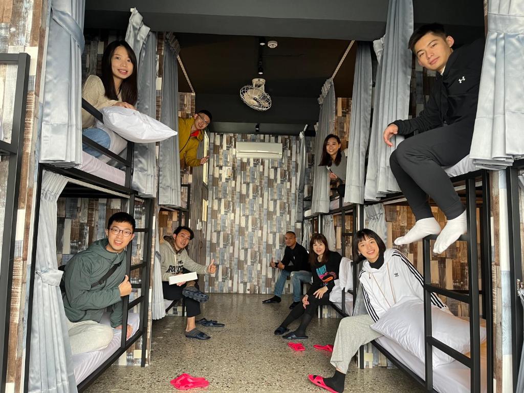 grupa osób siedzących na łóżkach piętrowych w obiekcie Topbunk Hostel w mieście Chishang