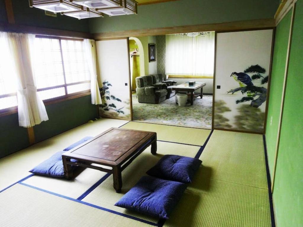 soggiorno con tavolo e cuscini blu di TOMA HOUSE - Vacation STAY 8723 a Sapporo
