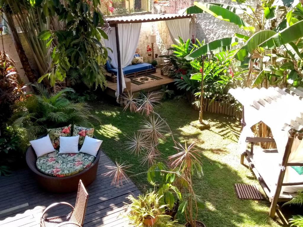 a garden with a chair and some plants at Villa Miracá Guest House in Maresias