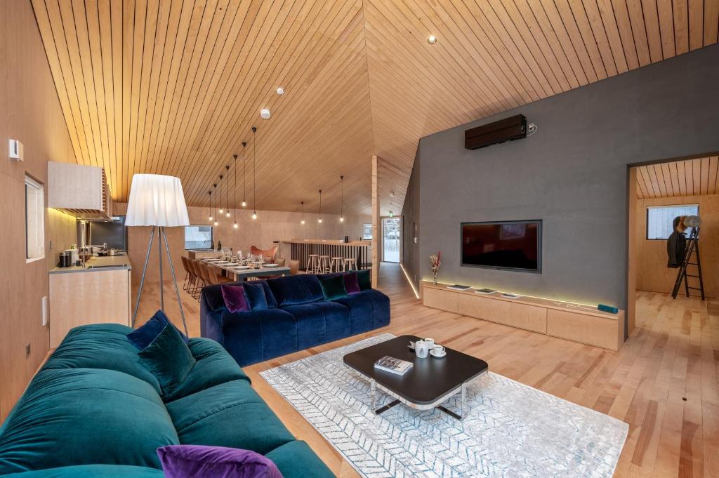 a living room with a blue couch and a table at Foxwood B by H2 Life in Niseko