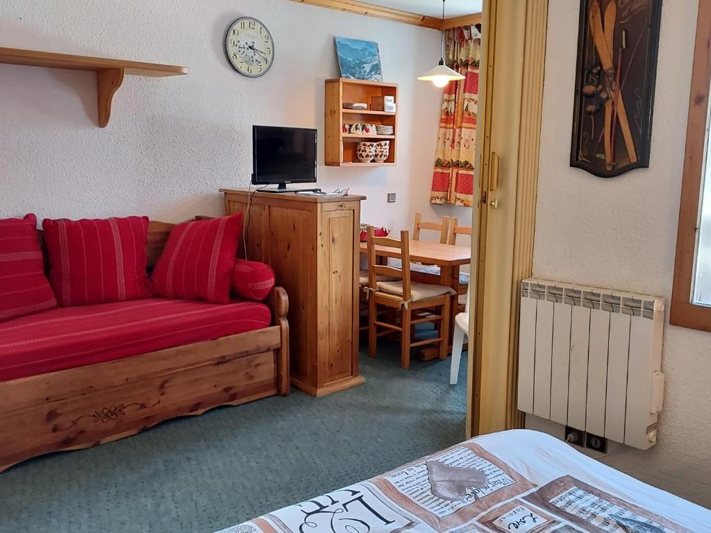 ein Wohnzimmer mit einem roten Sofa und einem Tisch in der Unterkunft Appartement Valmorel, 1 pièce, 4 personnes - FR-1-356-391 in Les Avanchers