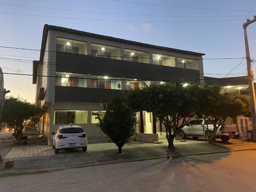 a building with a car parked in front of it at Pousada Costa dos Corais in São José da Coroa Grande