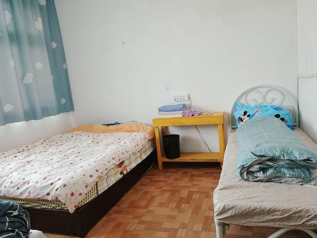 Postel nebo postele na pokoji v ubytování 金門瑜仙民宿-平價住宿-機車接送-洗衣Wifi-暢遊金門