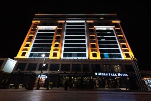 un edificio alto con luces encendidas por la noche en The Green Park Diyarbakir, en Diyarbakir