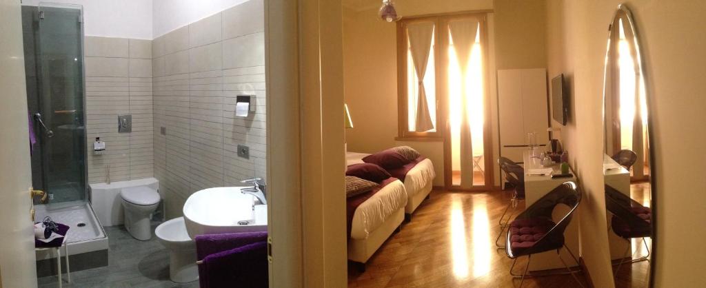 ローマにあるL'Appartamento Romanoのソファ、シンク、バスルームが備わる客室です。