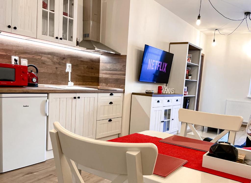 a kitchen with a table and a tv on the wall at Apartmán Rajecké Teplice in Žilina