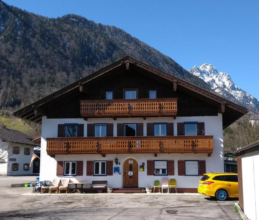 a building with a balcony with a mountain in the background at Landhaus Graßmann in Piding