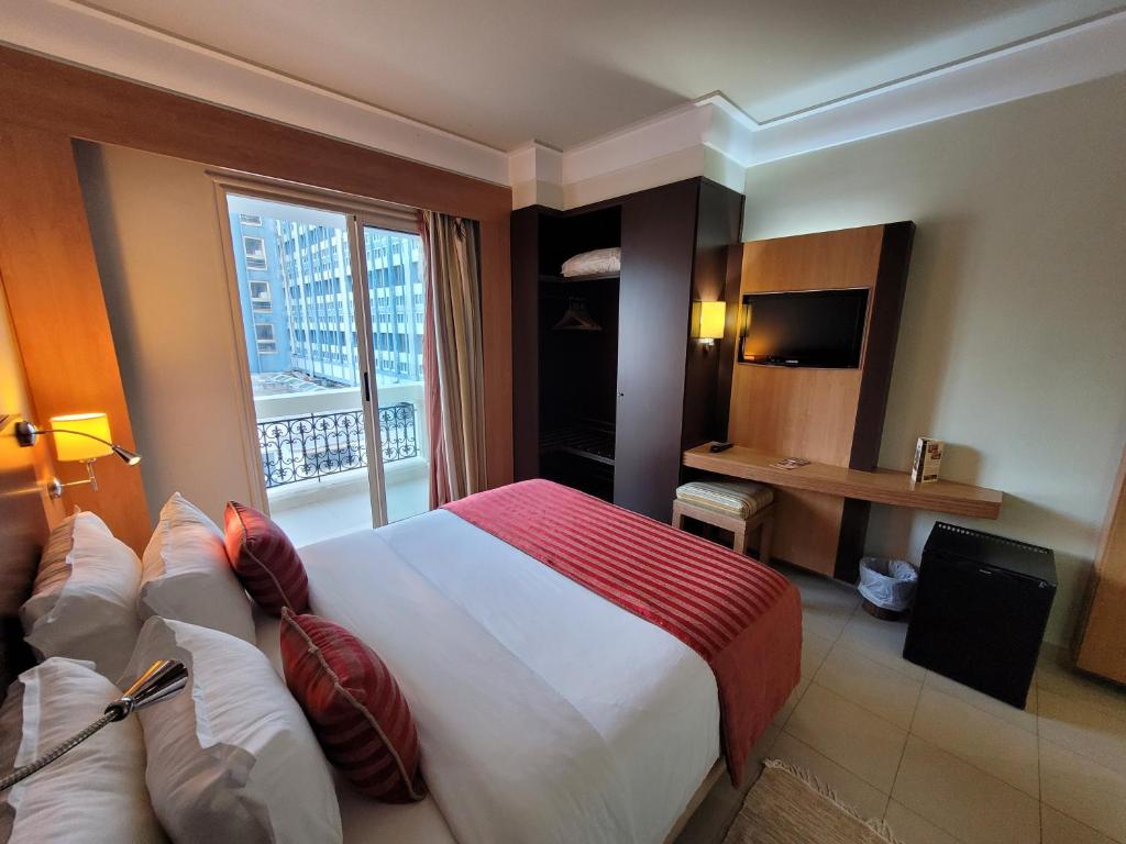 Una habitación de hotel con una cama grande y una ventana. en Hotel Tiba, en Túnez