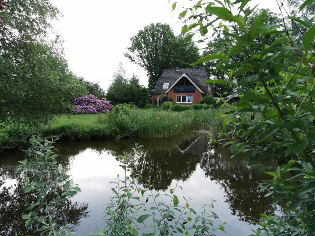 una casa reflejada en el agua de un estanque en Haus "Asgard" en Brinjahe