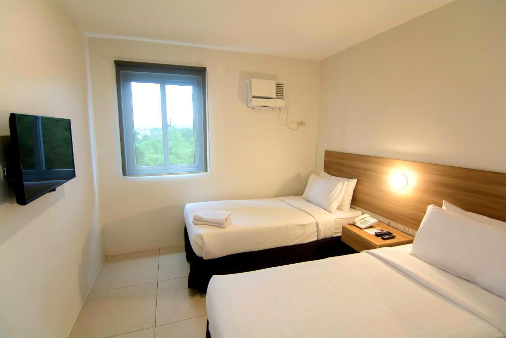 a hotel room with two beds and a television at Mango Suites in Tuguegarao City