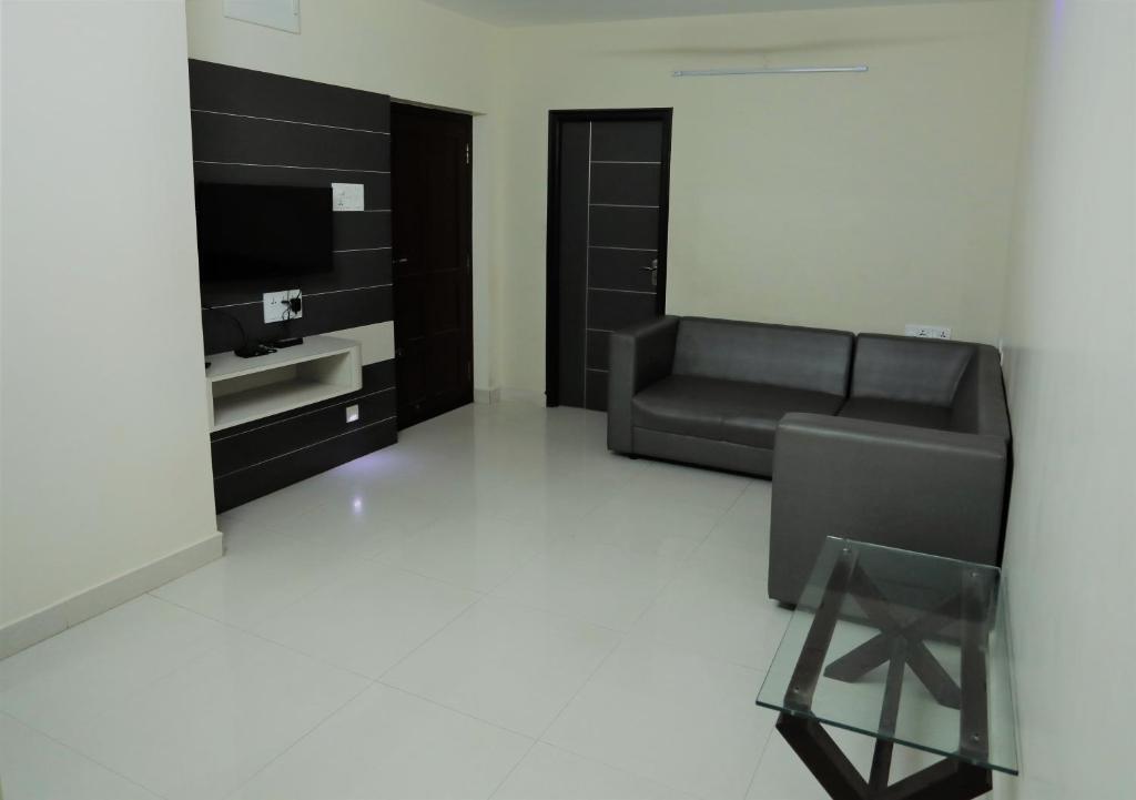 a living room with a couch and a television at Moonlight Residency in Tiruchchirāppalli