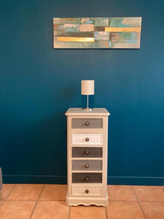 a white dresser with a lamp on top of it at Appartement &quot;Jardins&quot; in Pesmes