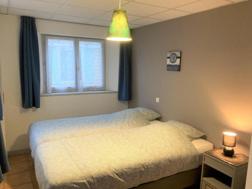 ein Schlafzimmer mit einem weißen Bett und einem Fenster in der Unterkunft Appartement "Jardins" in Pesmes