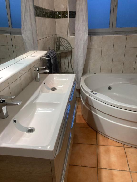 a bathroom with a tub and a toilet and a sink at Appartement &quot;Jardins&quot; in Pesmes