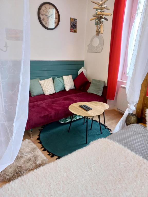 a living room with a red couch and a table at STUDIO DU VOYAGE GARE D AURAY in Brech