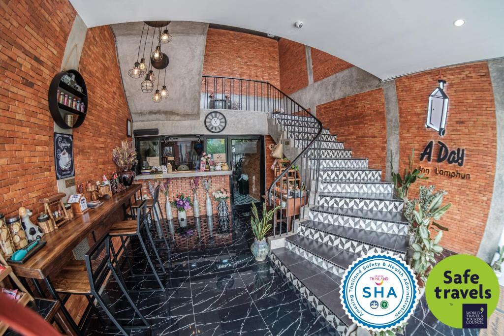 a restaurant with a staircase in a building at A Day Inn Lamphun in Lamphun