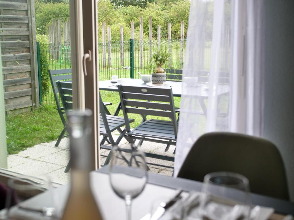 Elle offre une vue sur une terrasse avec une table et des chaises. dans l'établissement Cottage du Phare, 3 chambres & jardin, classé 3 étoiles, à Cayeux-sur-Mer