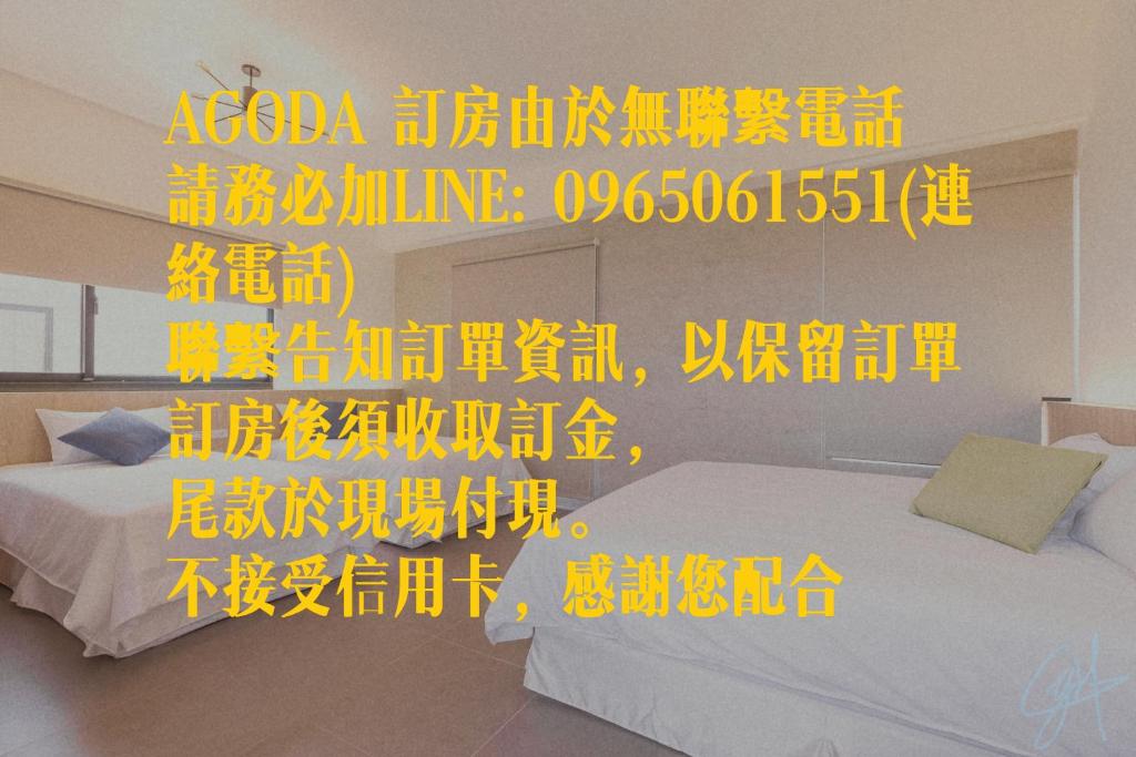 um quarto com duas camas com escrita amarela na parede em 大央島海景休閒民宿 em Magong