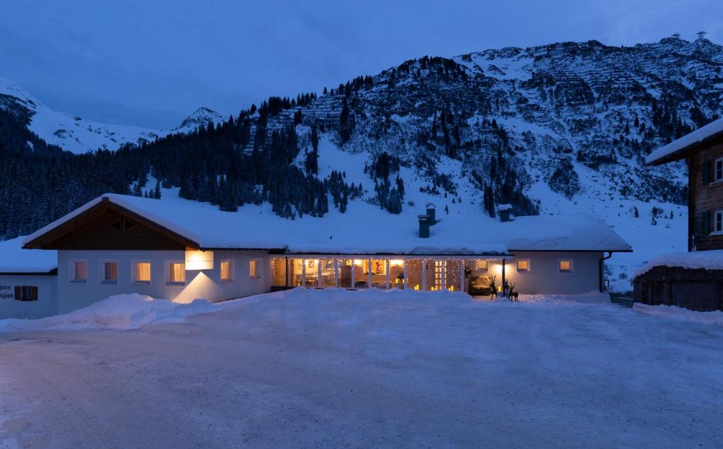 une maison éclairée la nuit dans la neige dans l'établissement Chalet Schneekristall, à Lech am Arlberg