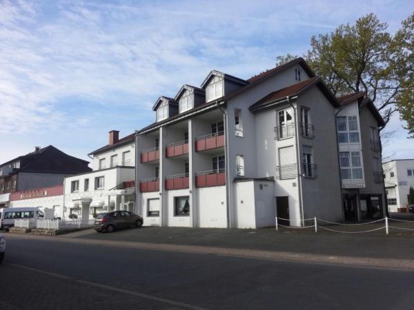 ein großes weißes Gebäude mit einem davor geparkt in der Unterkunft Bittscheidt´s Stadthotel in Datteln