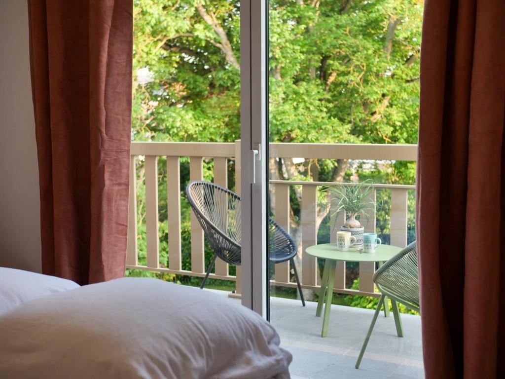 Cette chambre dispose d'un lit et d'un balcon avec une table et des chaises. dans l'établissement Apt. 50m du port de plaisance, Parking & Ascenseur, à Saint-Valery-sur-Somme