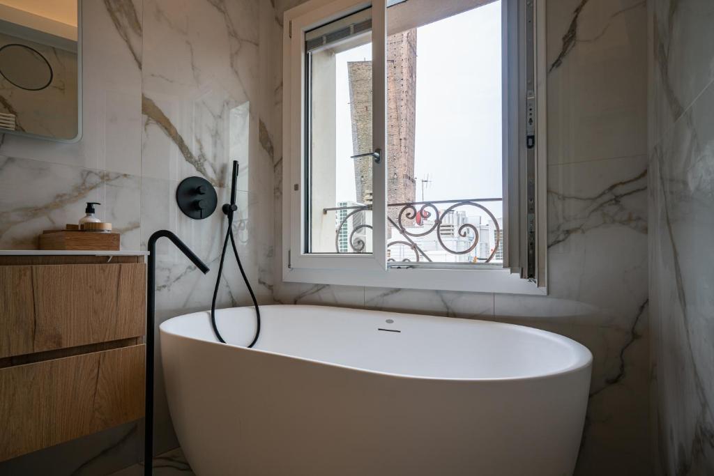 uma banheira branca na casa de banho com uma janela em PANORAMA APARTMENT em Bolonha
