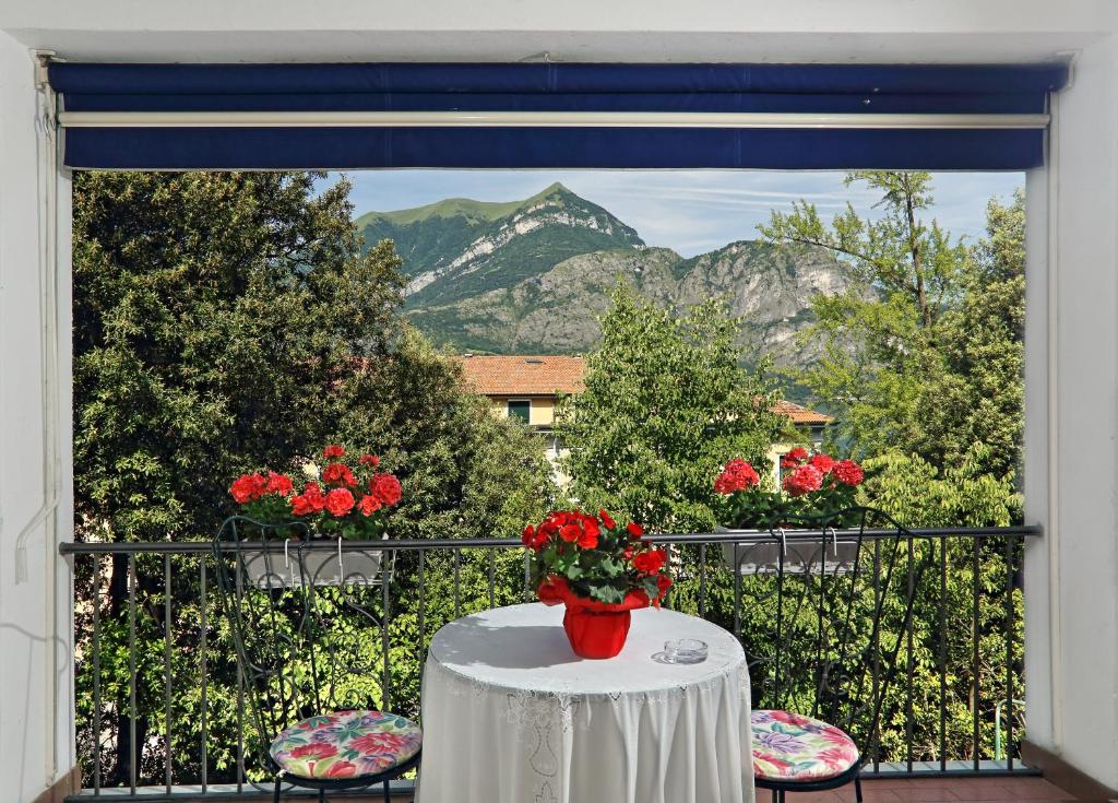 einen Tisch mit einer Blumenvase auf dem Balkon in der Unterkunft Haus Bethusy in Bellagio