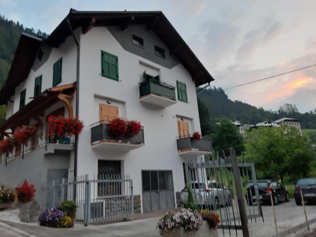 a white house with flowers on the windows at Casa Stefani in Commezzadura