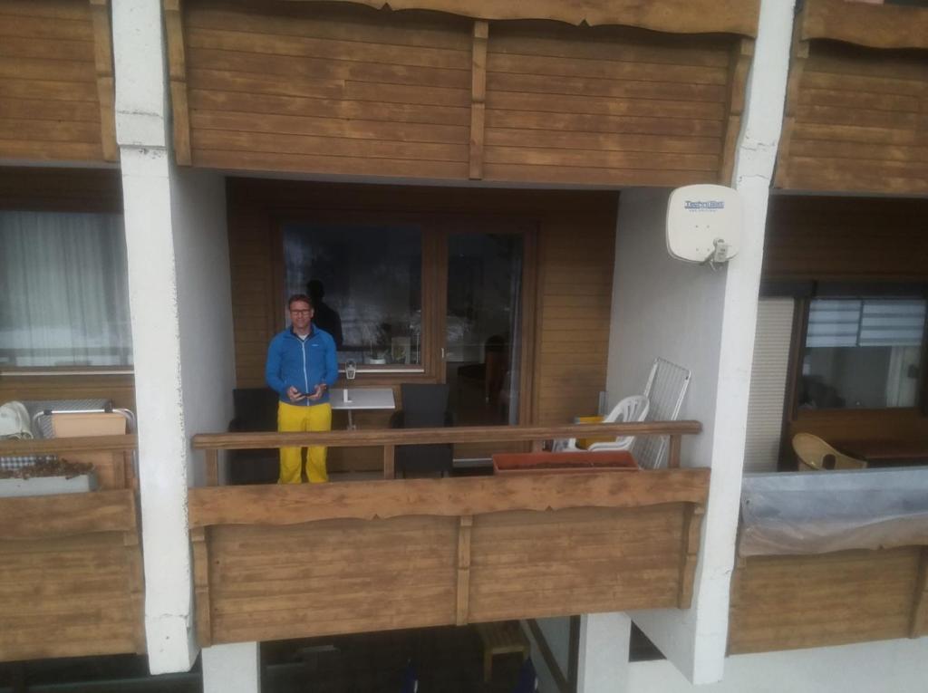 um homem de pé numa varanda num edifício em Haus Norea, Top 65 em Sankt Urban