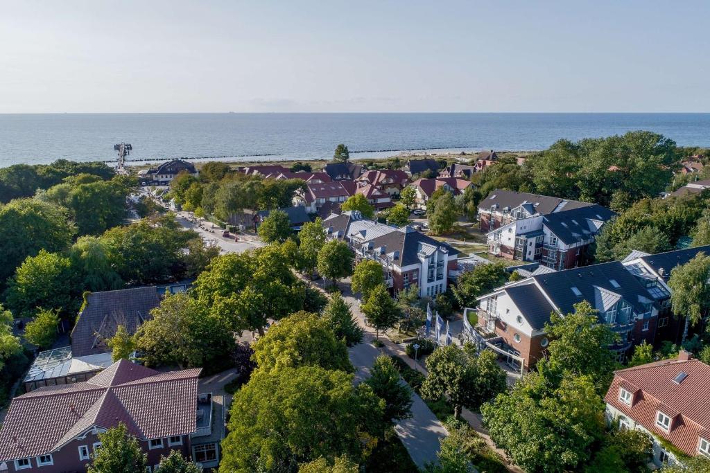 una vista aérea de una pequeña ciudad con casas y el océano en Dorint Strandresort & Spa Ostseebad Wustrow en Wustrow