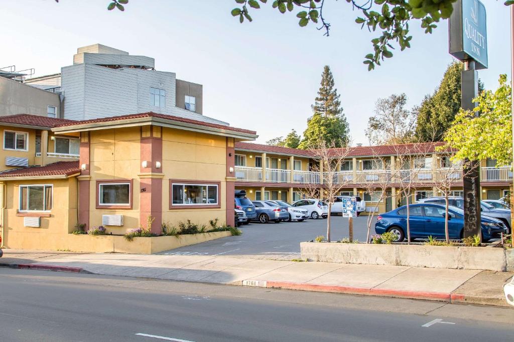 Quality Inn University Berkeley في بيركلي: مبنى فيه سيارات متوقفة في موقف للسيارات