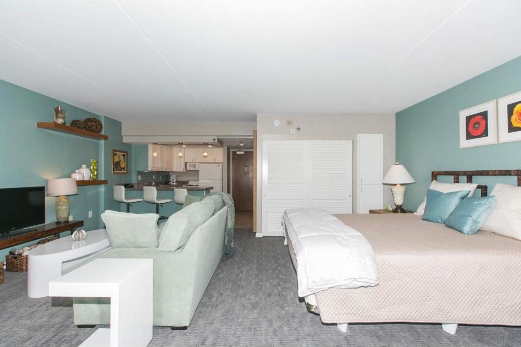 1 dormitorio con cama, sofá y sala de estar en Ilikai Tower 1 Bedroom City View Condos with Private Lanai & Free Wifi! en Honolulu