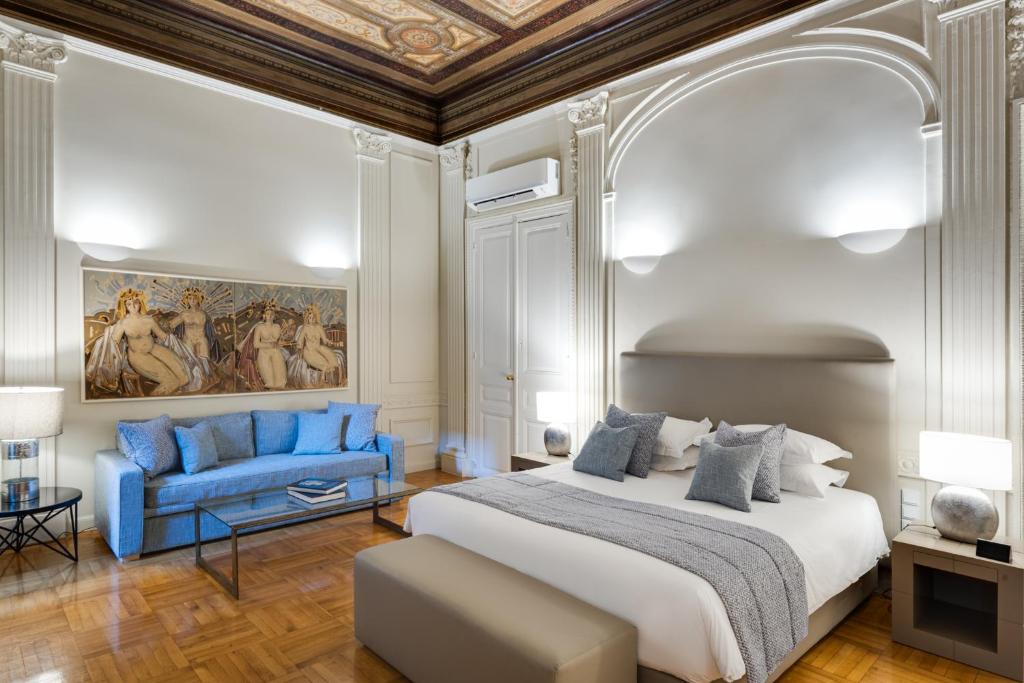 una camera con letto king-size e divano blu di 33SolonosSuites ad Atene
