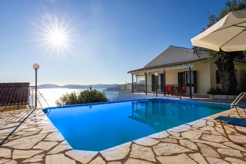 a swimming pool in front of a house at Villa Georgina in Nisakion