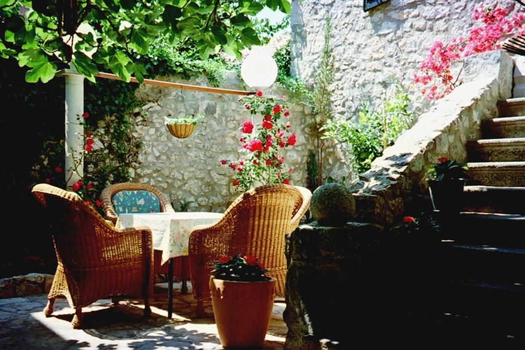 d'une terrasse avec des chaises en osier et une table fleurie. dans l'établissement Studio apartment in Novi Vinodolski with terrace, air conditioning, WiFi 4208-1, à Novi Vinodolski