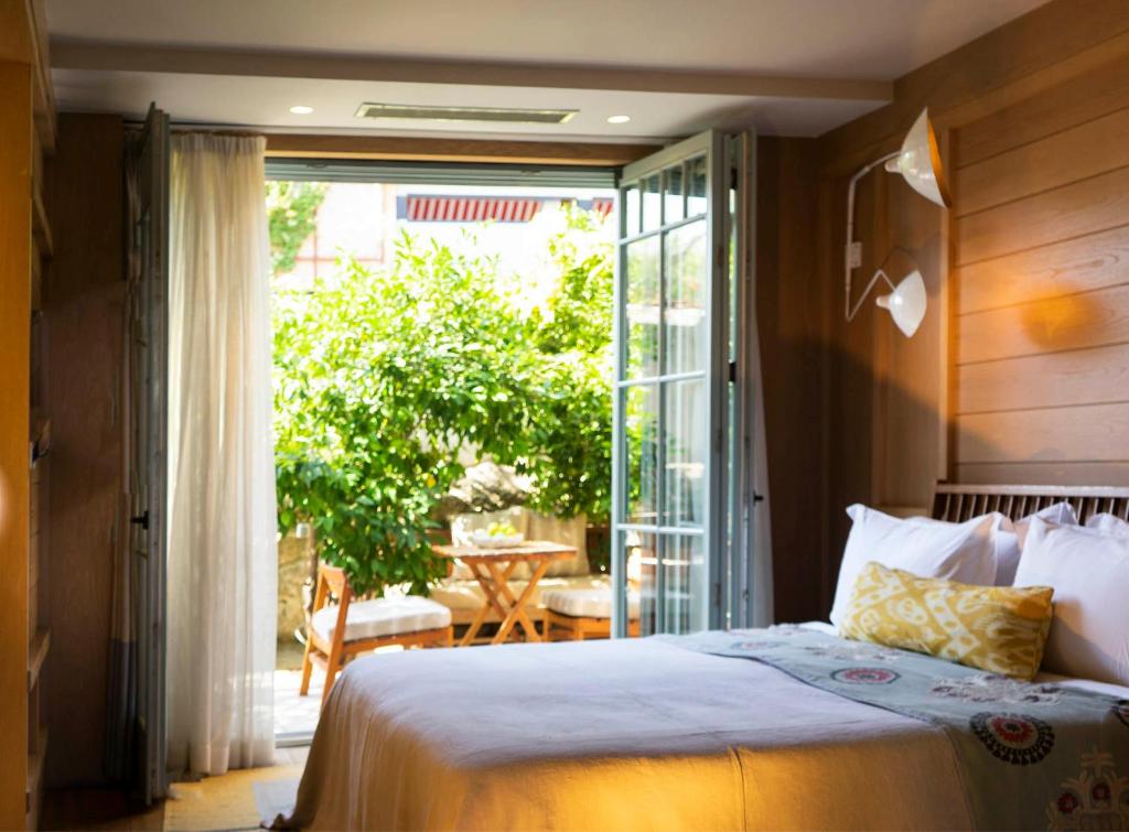 a bedroom with a bed and a sliding glass door at Alavya in Alaçatı