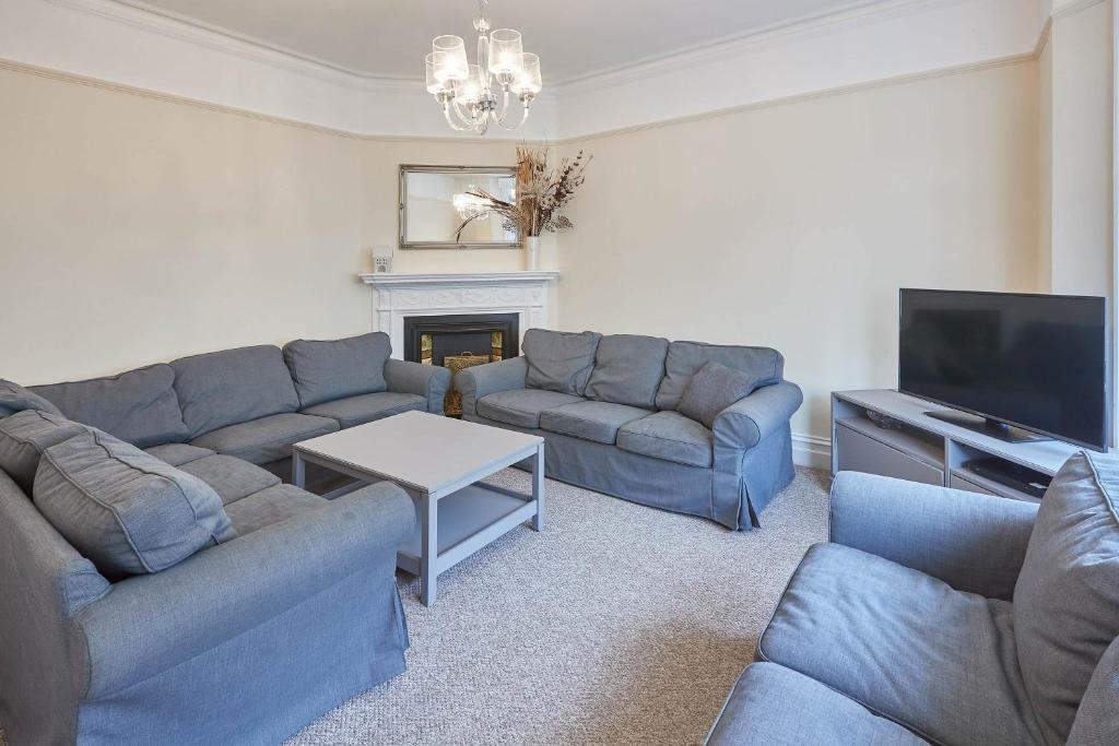 a living room with blue couches and a tv at Host & Stay - The Townhouse in Scarborough