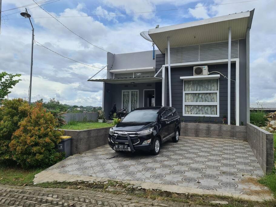 um carro estacionado em frente a uma casa em Bandar Lampung Villa em Kedaton