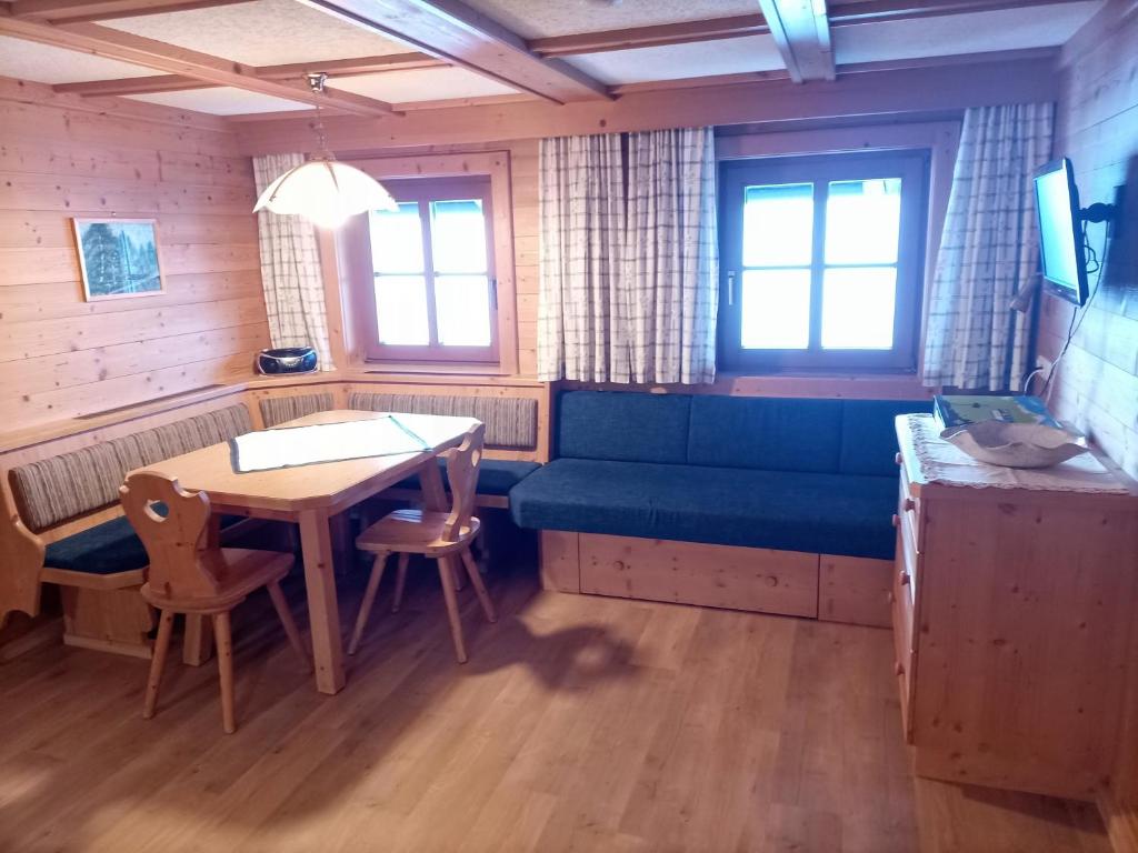 salon z niebieską kanapą i stołem w obiekcie Plonerhof w mieście Hopfgarten in Defereggen