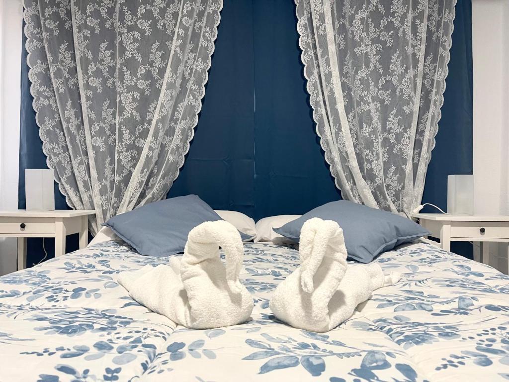 a bed with two swans towels sitting on it at Edificio Sierra, 35 in Los Cristianos