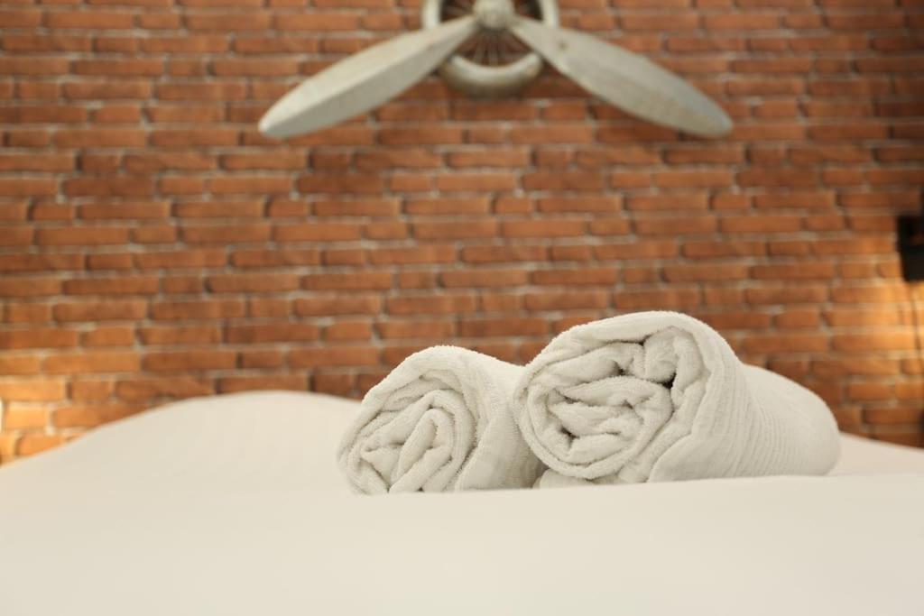 - une paire de serviettes sur un lit avec un ventilateur de plafond dans l'établissement Loft Indus, à Chamalières