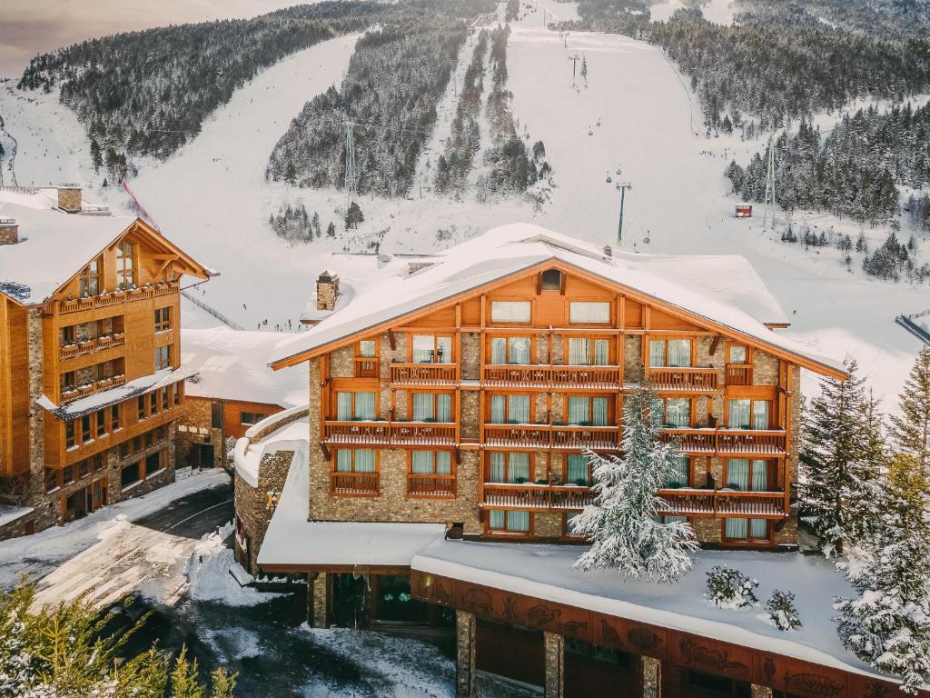 un lodge de esquí con nieve en el techo en Sport Hotel Village, en Soldeu