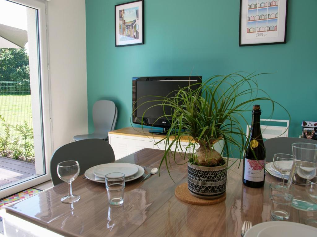 - une table avec une bouteille de vin et une plante en pot dans l'établissement Maison neuve lumineuse avec jardin, parking privé, à Saint-Valery-sur-Somme